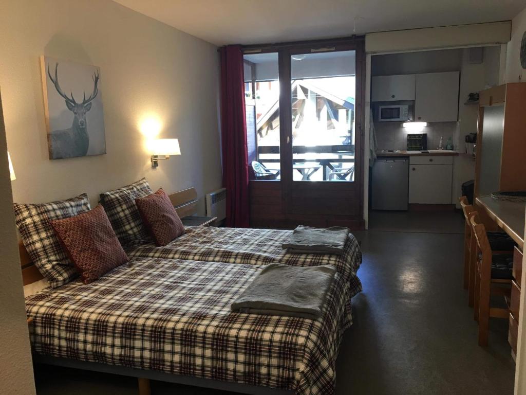 - une chambre avec un lit et une couverture tressée dans l'établissement Brides-les-Bains family ski and spa appartment, à Brides-les-Bains
