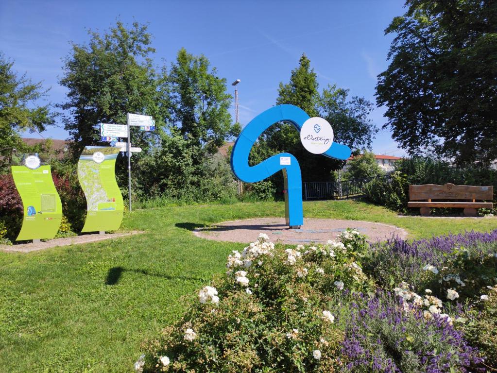 a blue sign in a park with flowers at Abschalten am Albsteig in Albbruck im Süd-Schwarzwald großzügige Ferienwohnung in Albbruck