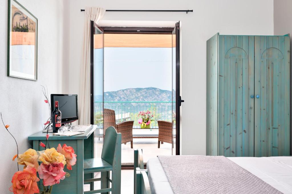 Schlafzimmer mit einem Schreibtisch, einem Computer und einem Fenster in der Unterkunft S'Enis Monte Maccione in Oliena