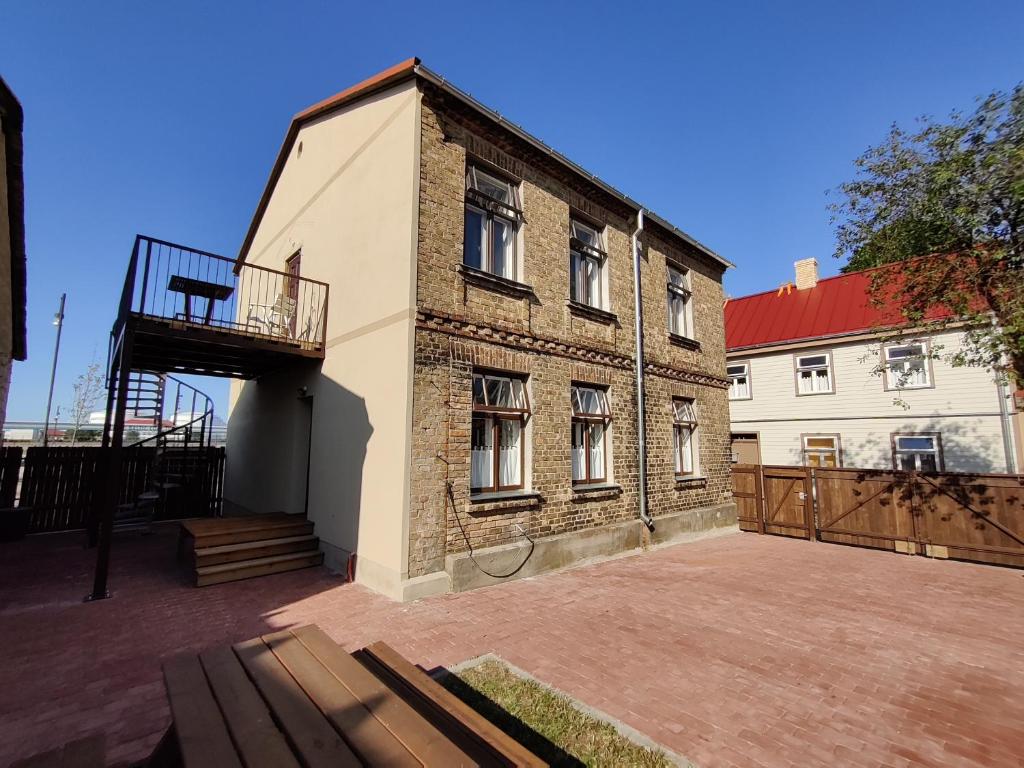 un edificio de ladrillo con un balcón en el lateral. en Promenādes apartamenti, en Ventspils