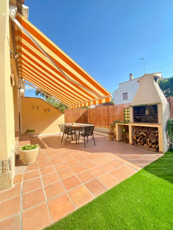 un patio con mesa y parrilla en CAN LOLA Estupenda casa de 4 habitaciones con jardín a 150 metros de la playa en Torredembarra