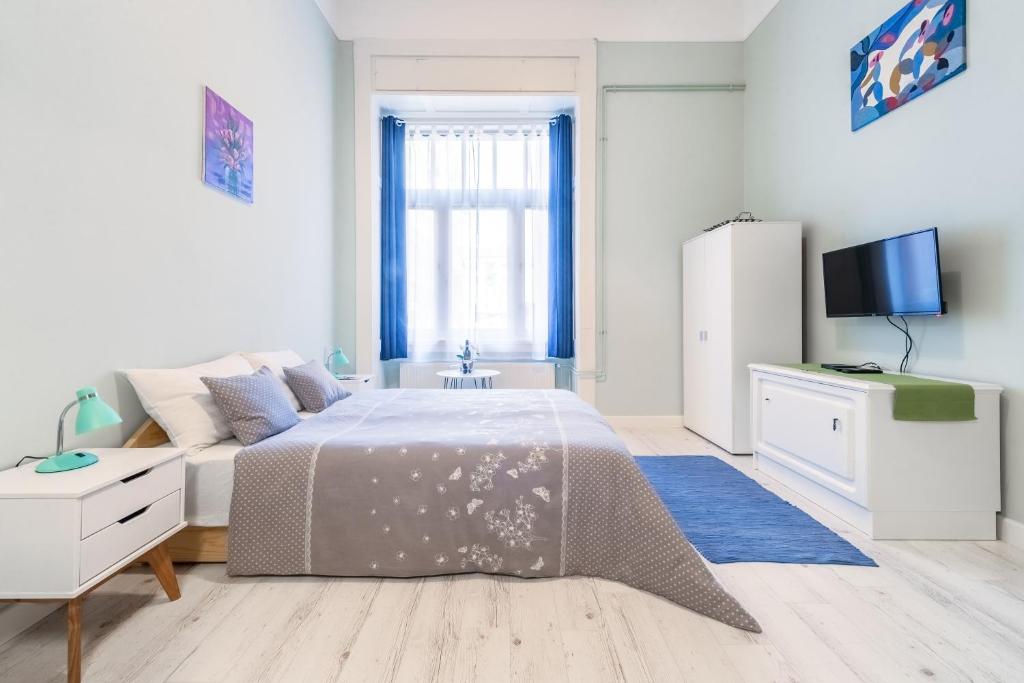 Hotel Central Studio Budapest, a white bedroom with a bed and a tv at Central Studio Budapest in Budapest