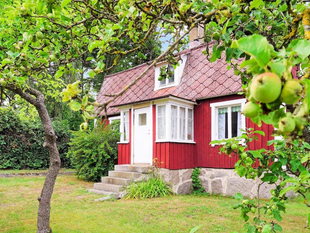 a red house with a white door and a tree at 4 person holiday home in SÖLVESBORG-By Traum in Sölvesborg
