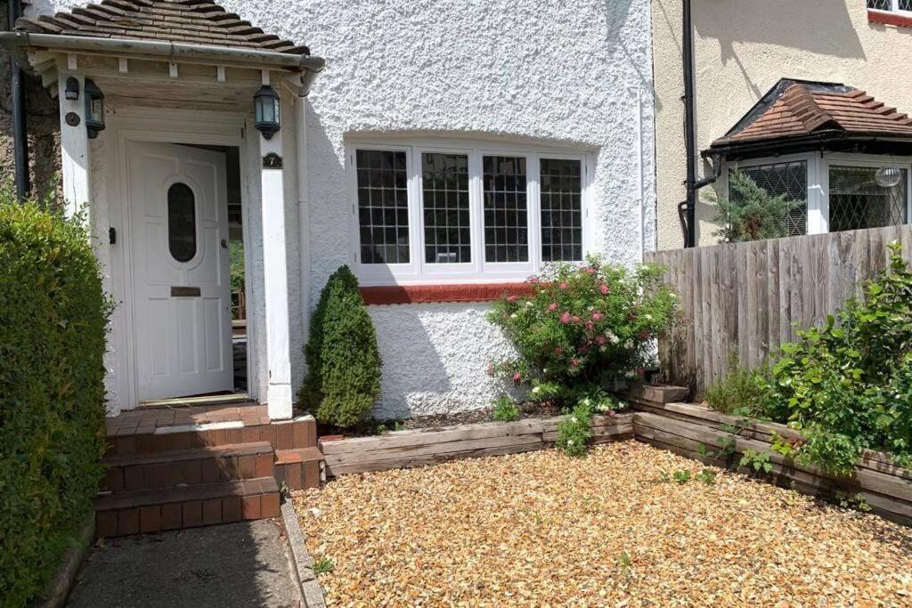 una casa blanca con una puerta blanca y una valla en Garden Suburbs Cottage en Crosskeys