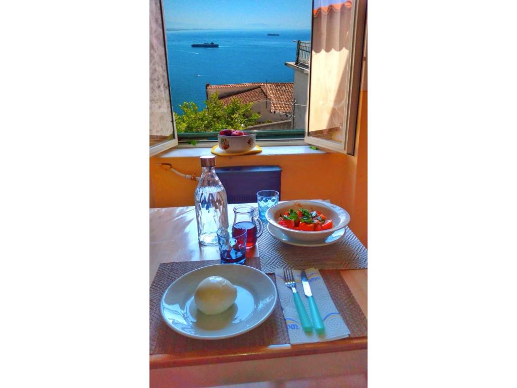 un tavolo con piatto di cibo e vista sull'oceano di SPICCHIO DI MARE -vista mare- a Vietri