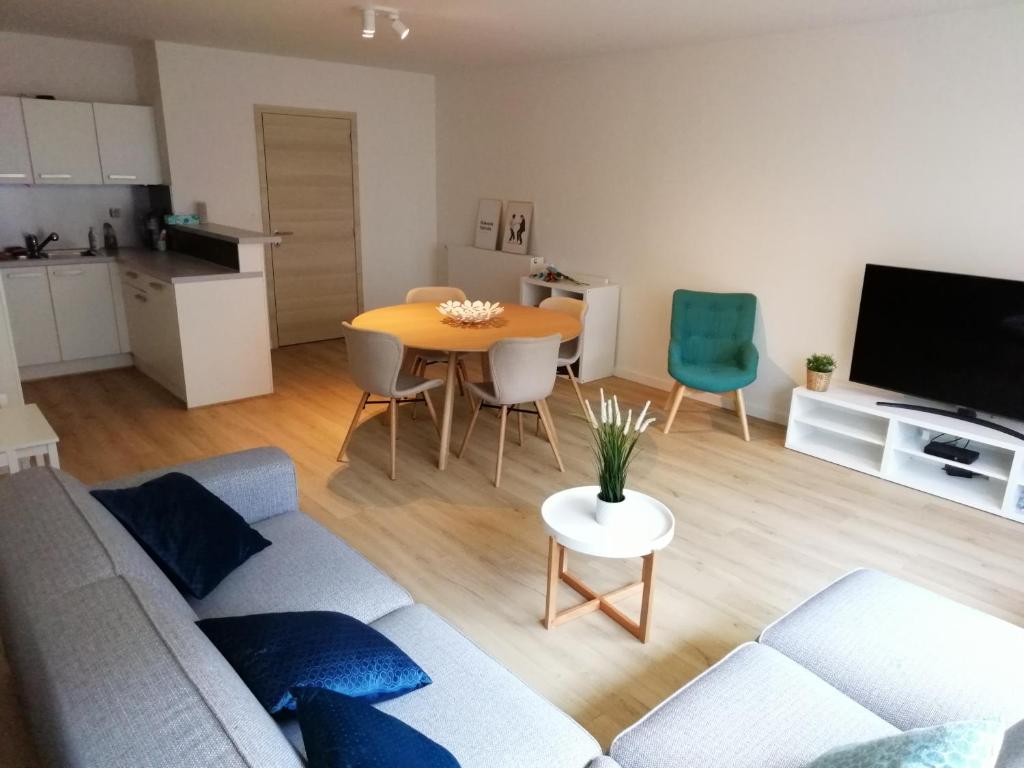 a living room with a couch and a table at Hakuuna Matata Appartement Koksijde met staanplaats in Koksijde