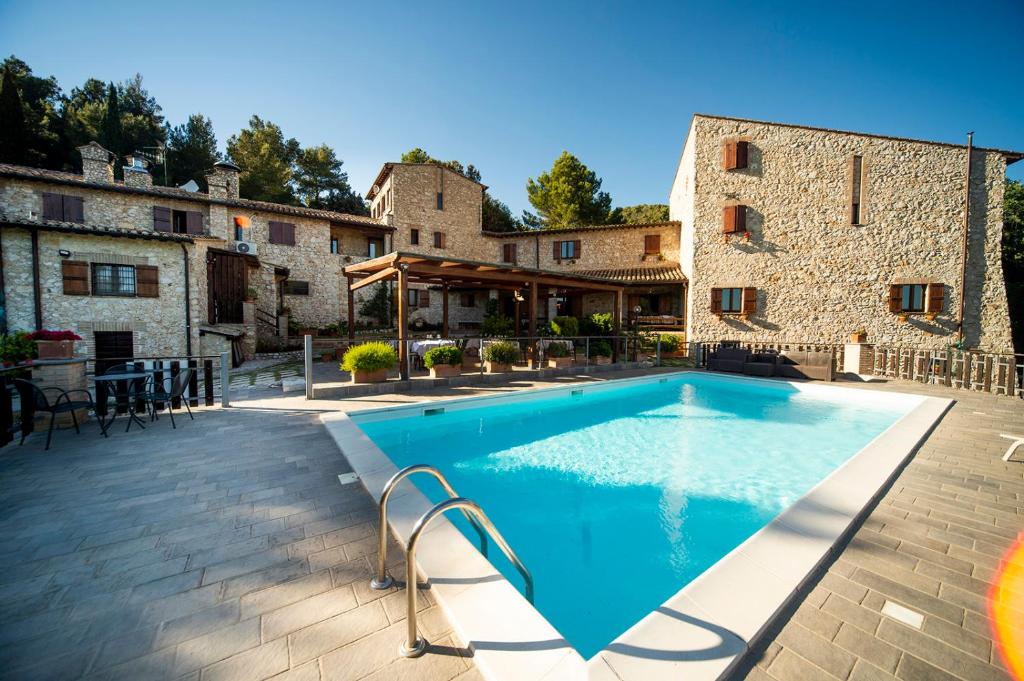 a swimming pool in front of a building at Albergo Fontanelle in Campello sul Clitunno