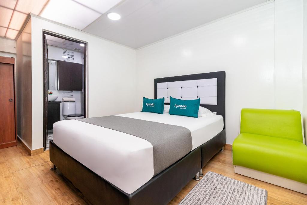 1 dormitorio con 1 cama y 1 silla verde en Ayenda Casa Alvarez, en Bogotá