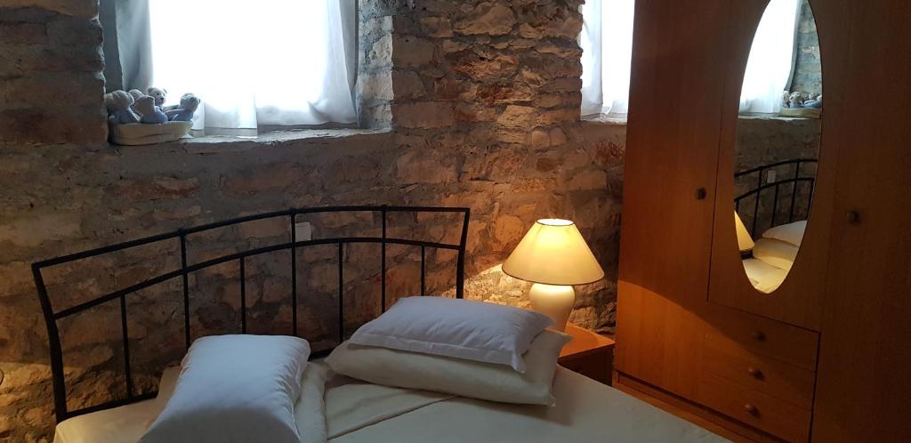 sypialnia z łóżkiem, lampką i oknem w obiekcie Rooms & Apartment STELIO w mieście Loborika
