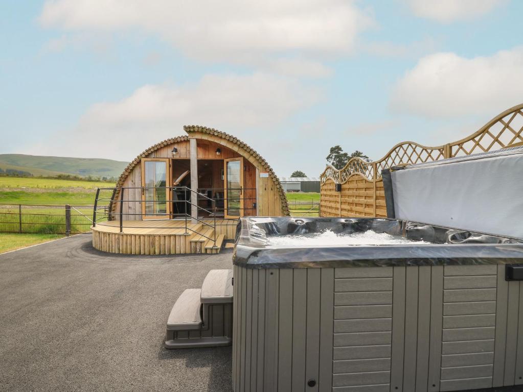 a large tub sitting in front of a house at Bluebell in Rhayader