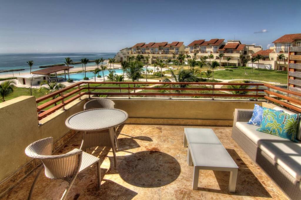 a balcony with a table and chairs and the ocean at Beachfront Paradise Luxury Penthouse Punta Cana in Punta Cana