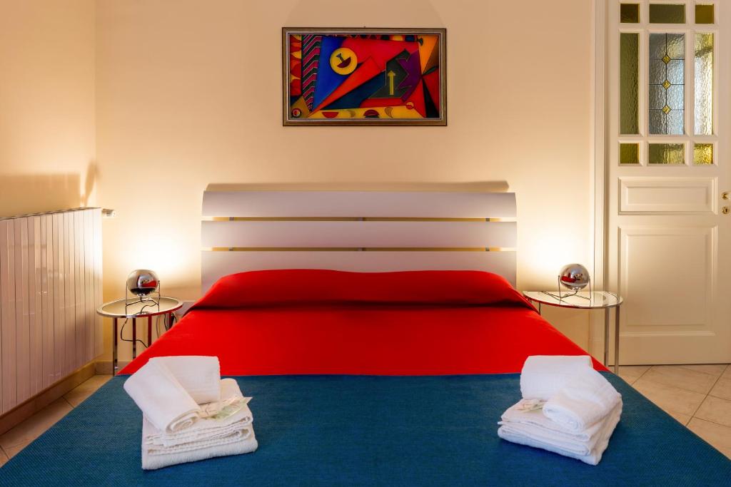 シャッカにあるB&B Torre Lauroのベッドルーム1室(赤いベッド1台、タオル2枚付)