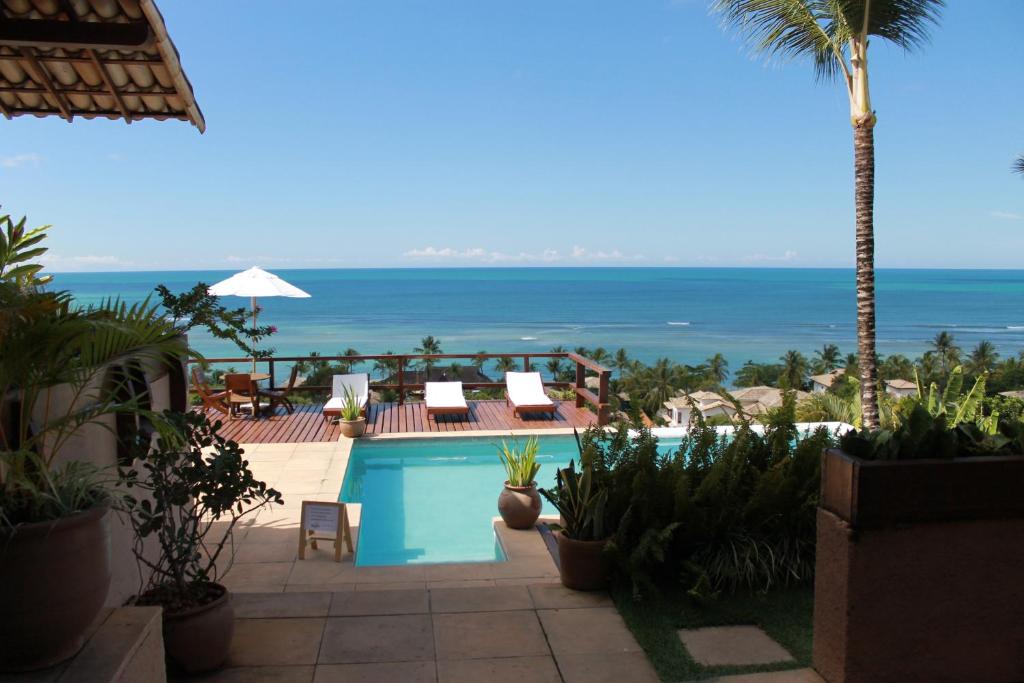 a swimming pool with a view of the ocean at Baixu Village in Arraial d'Ajuda