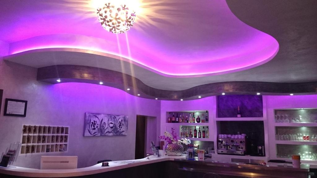 a bar with purple lights on the ceiling at Hotel Ogliastra in Lotzorai