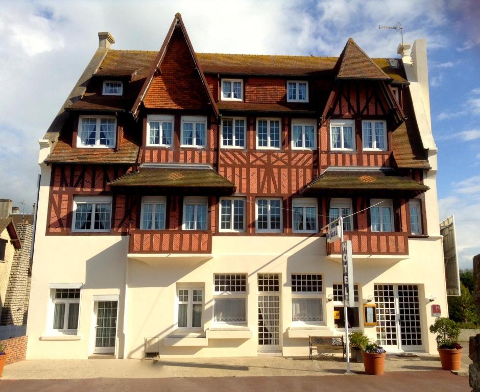 un grand bâtiment avec un toit en bois dans l'établissement Hôtel De La Mer - Deauville Blonville - Boutique Hôtel de charme vue Mer ou Campagne - Accès direct plage, à Blonville-sur-Mer