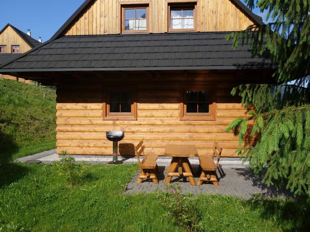 a cabin with a picnic table and chairs in front of it at Drevenica pod smrekom in Terchová