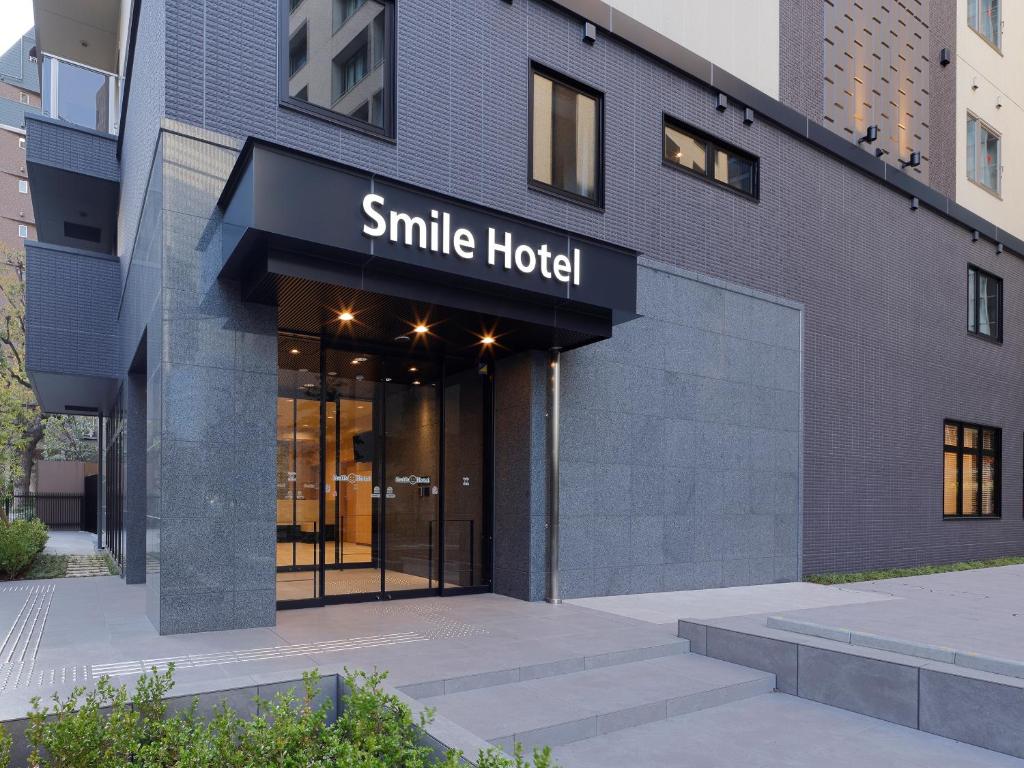 a large building with a smile hotel sign on it at Smile Hotel Osaka Nakanoshima in Osaka