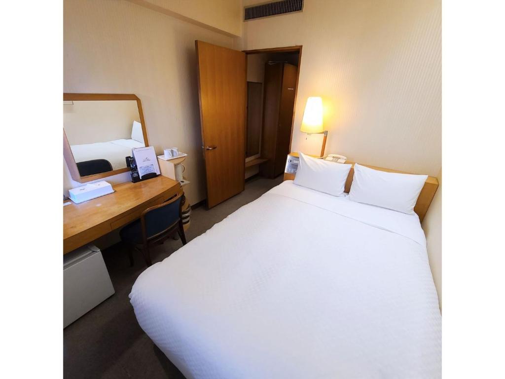 a hotel room with a large bed and a desk at Court Hotel Fukuoka Tenjin - Vacation STAY 42330v in Fukuoka