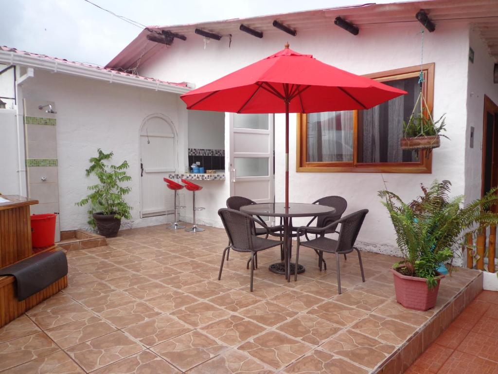 a patio with a table and chairs and an umbrella at Zurisadai in Puerto Ayora