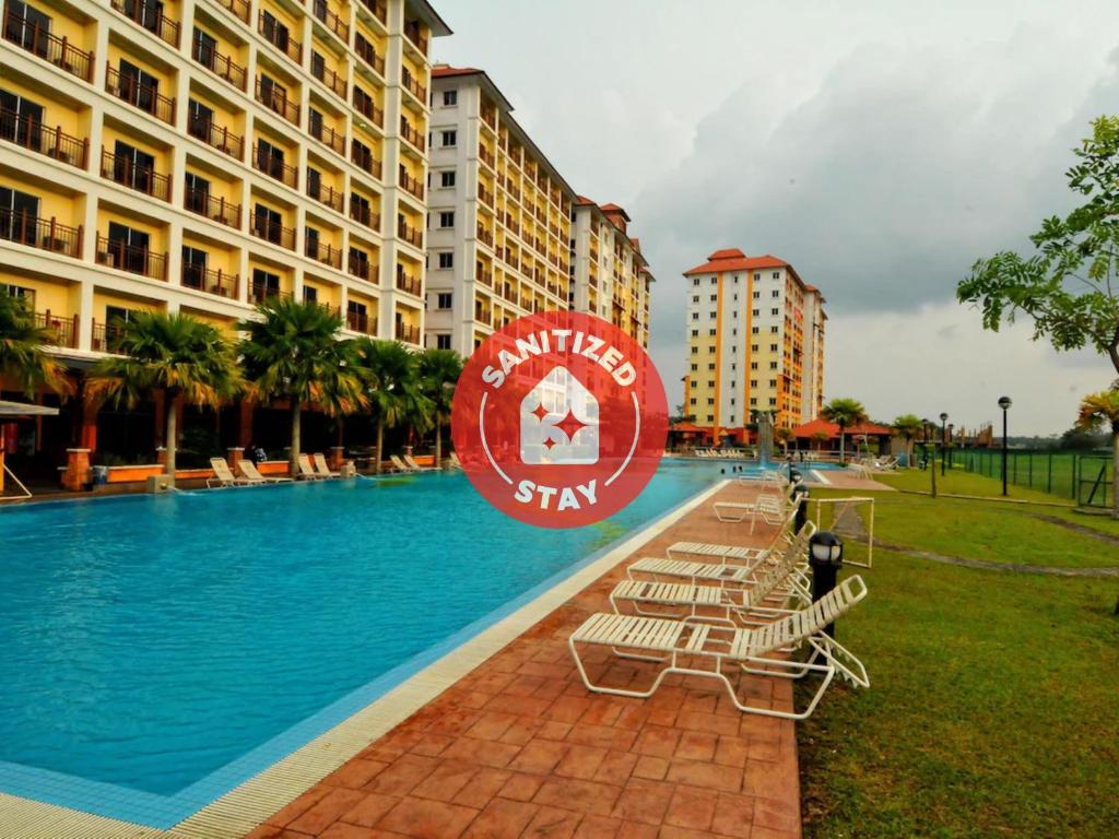a swimming pool with lounge chairs and a hotel at OYO HOME 90301 Suria Service Apartments Bukit Merak Laketown Resort in Taiping