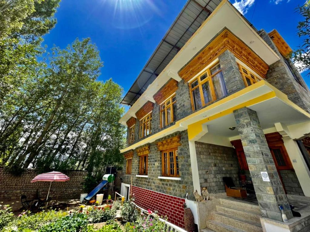 uma casa com o sol no céu em Hidden Leaf Homestay em Leh