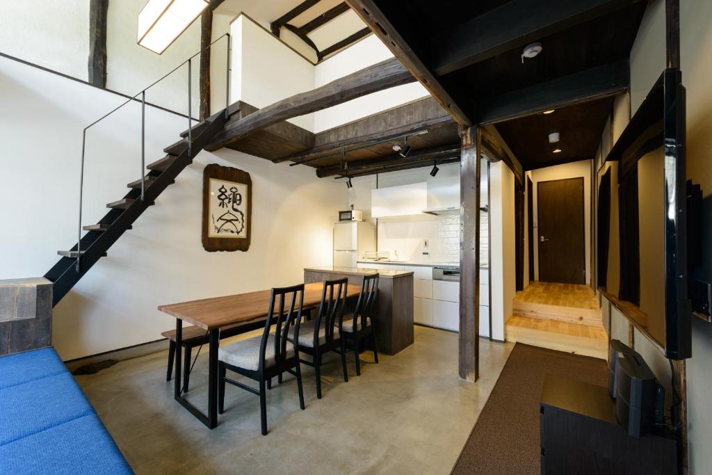 uma cozinha e sala de jantar com uma mesa de madeira e cadeiras em Shiki Homes TSURU KAME em Quioto