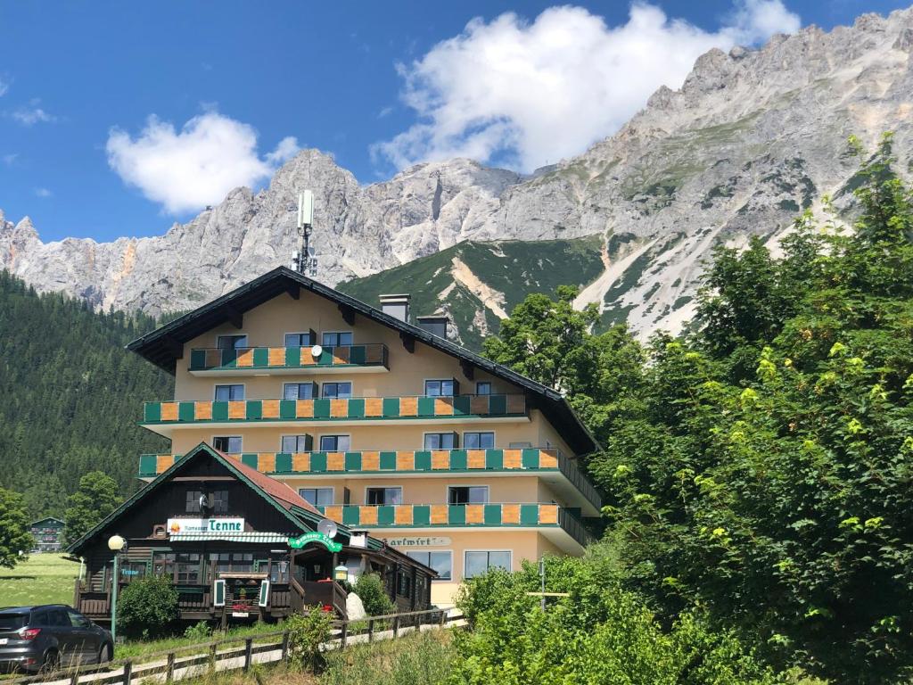 a large building in front of a mountain at Romantik Apartment mit SommerCard in Ramsau am Dachstein