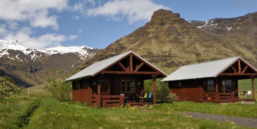 una cabina in un campo con una montagna sullo sfondo di North Star Cottage a Eyvindarhólar