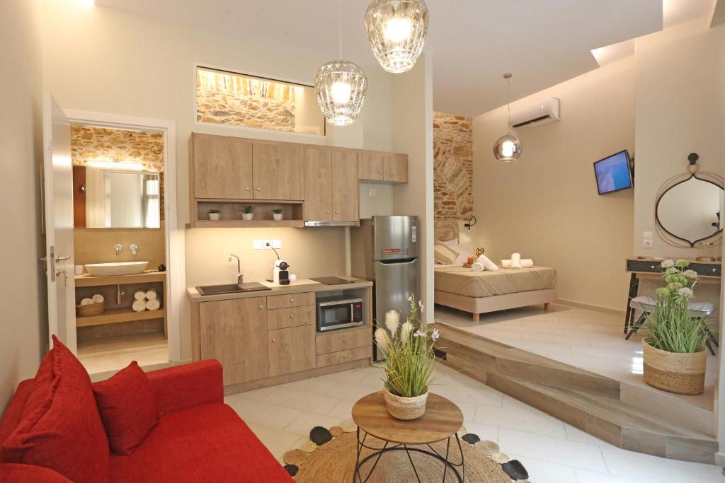 Il comprend un salon avec un canapé rouge et une cuisine. dans l'établissement One Suite Syros, à Ermoúpoli