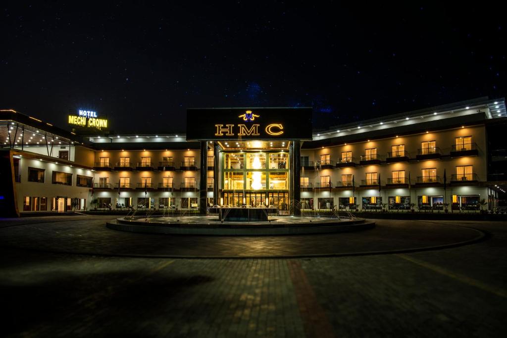 un grande edificio con un cartello sopra la notte di Hotel Mechi Crown a Kakarvitta