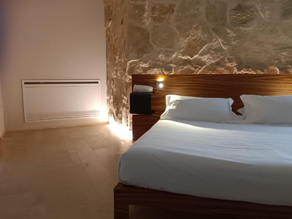 a bedroom with a bed and a lamp at Chiusa Di Carlo Agriturismo in Avola