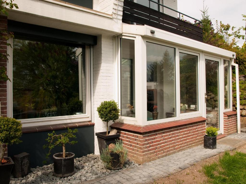 a screened in porch with windows and potted plants at Art of Living in Plön