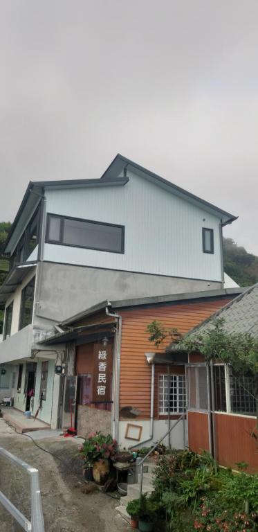 a large house with a white roof at Green incense Homestay in Zhuqi