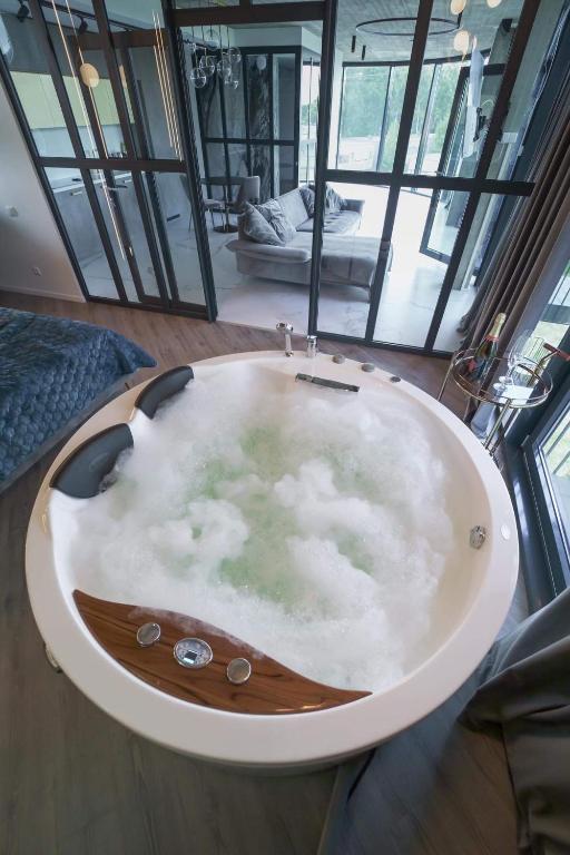 a bathroom with a bath tub with clouds in it at Exclusive Jacuzzi Apartaments Klaipėda in Aukštkiemiai