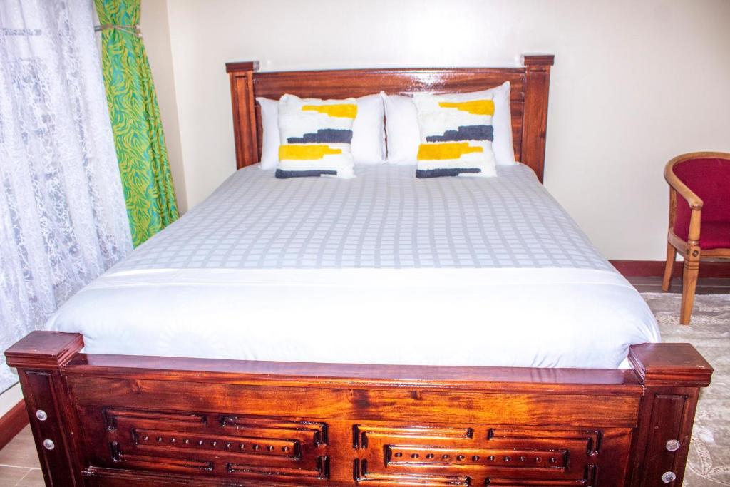 a bed in a room with a wooden bed frame at Kasty G Studio - W Place Apartments in Nairobi