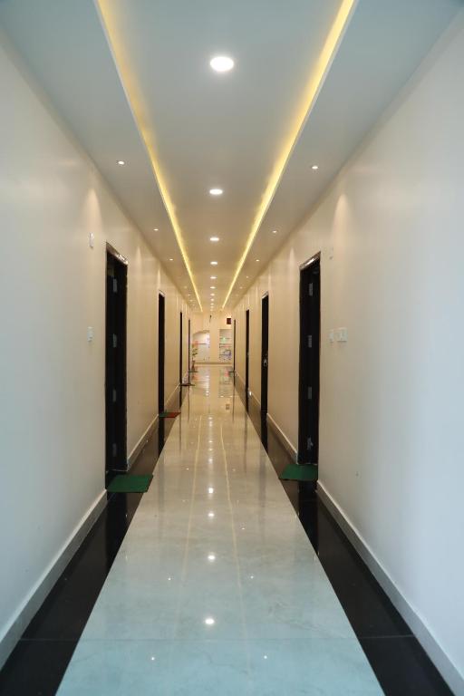 a corridor of a building with white walls and a long hallway at Hotel shri siddhivinayak in Bīna-Etāwa