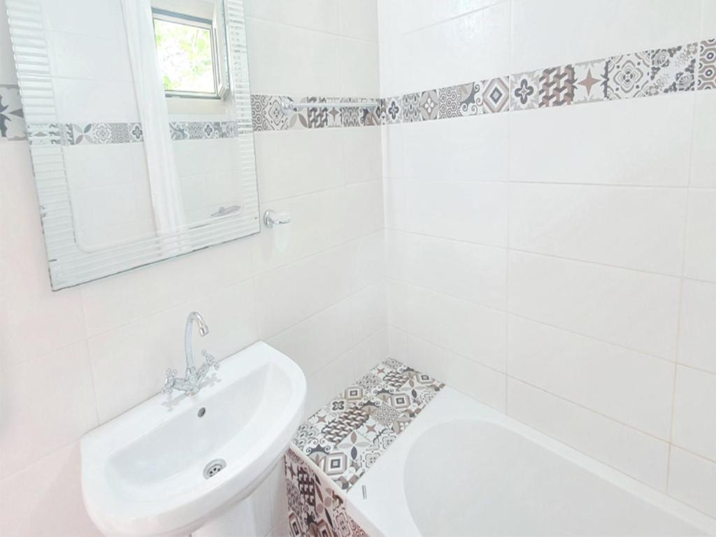 biała łazienka z umywalką, wanną i toaletą w obiekcie Room in Apartment - Spacious Room in Creta for 3 people, with Ac, Swimming Pool and Nature w mieście Hersonissos