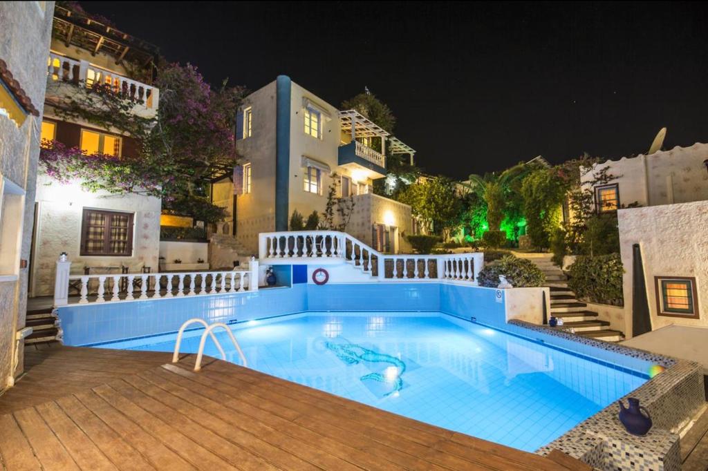 a large swimming pool in a backyard at night at Muster Suite full view in Hersonissos