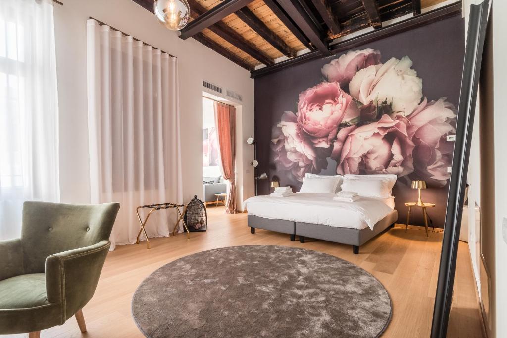1 dormitorio con 1 cama y una pintura de flores en Blooms Botanical Rooms, en Padua