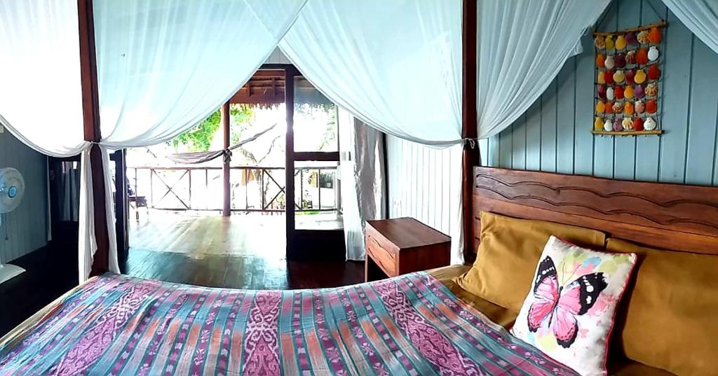 a bedroom with a bed with butterfly pillows at Nini's Beach Bungalows in Bira
