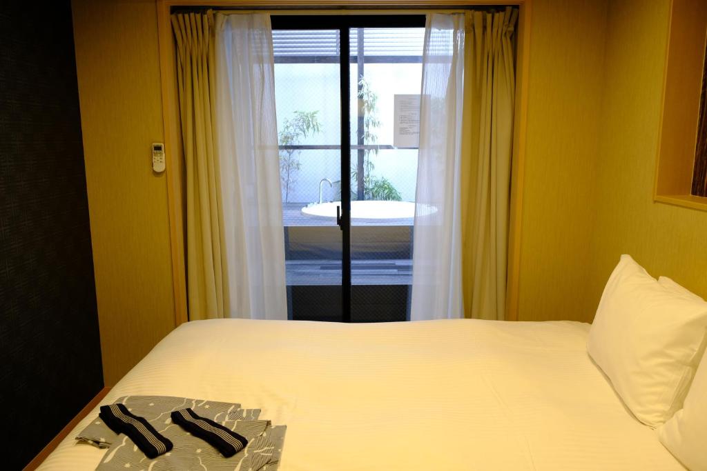 Postel nebo postele na pokoji v ubytování Shiki Suites - Kyoto Umekoji
