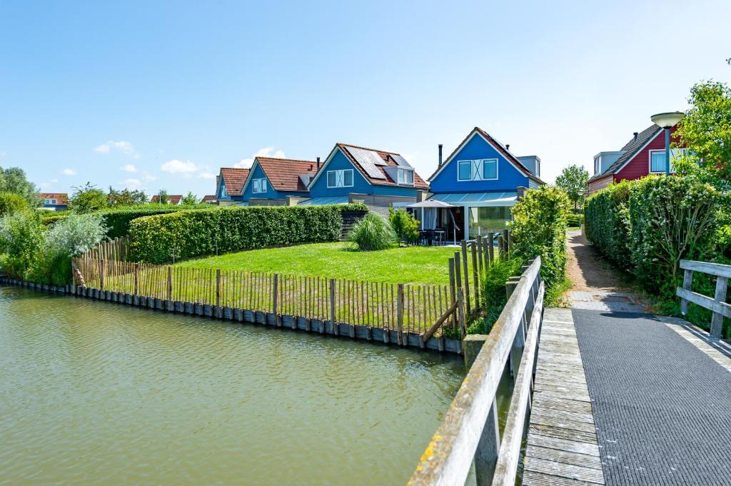 uma fila de casas junto a um rio em Antibes 258 - Kustpark Village Scaldia em Hoofdplaat