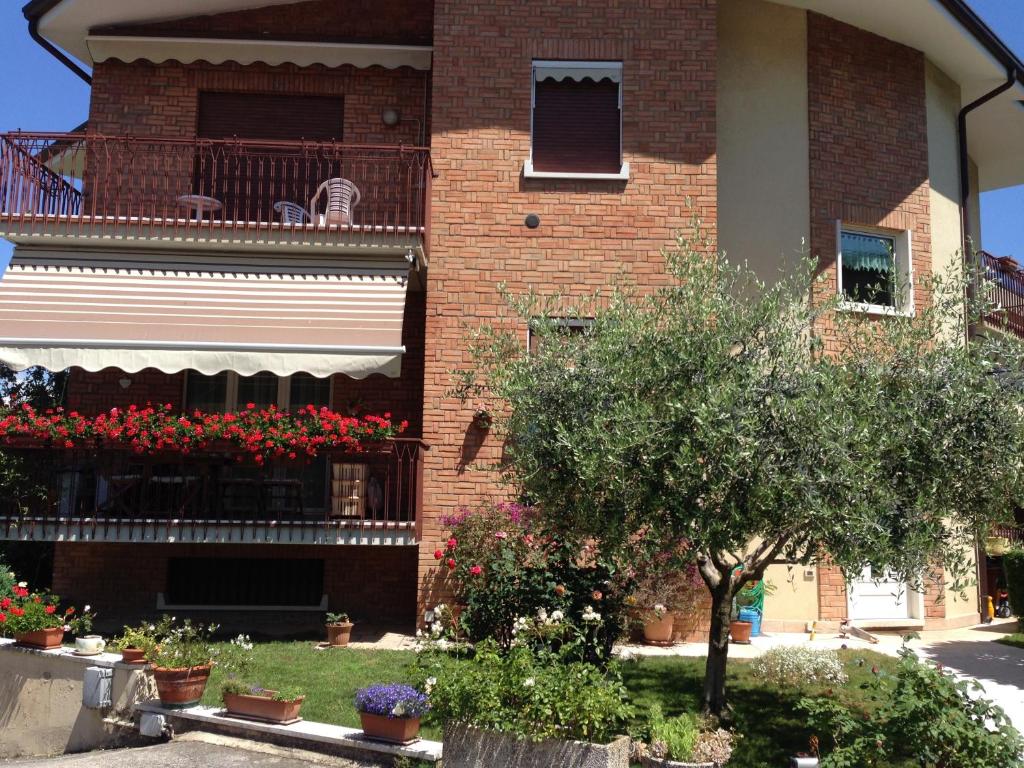 ein Backsteingebäude mit einem Balkon mit Blumen darauf in der Unterkunft Appartamenti Poggio di Giano in Poiano