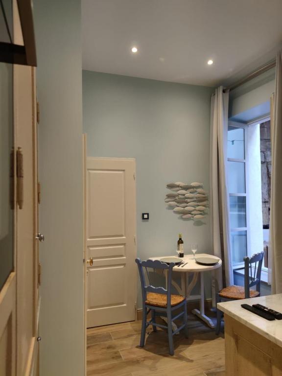 a kitchen and dining room with a table and chairs at Mes à Moi in Pezenas - Studio &amp; patio privatif - O Pitchoun in Pézenas