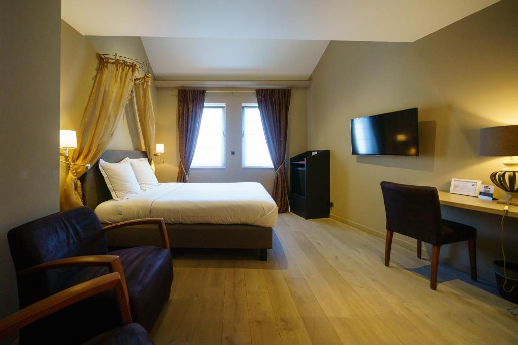 デュルビュイにあるホテル サンタ ムールのベッド、デスク、椅子が備わるホテルルームです。