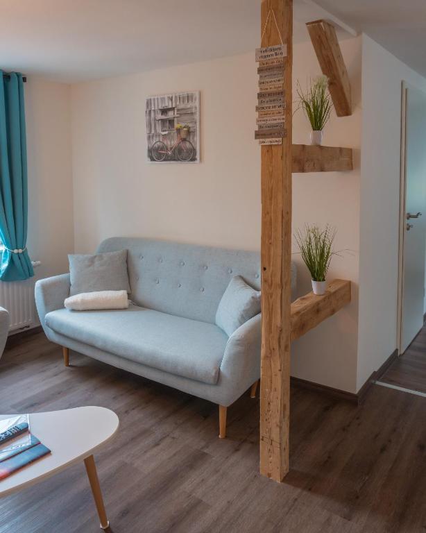 a living room with a blue couch and a loft bed at Appartementhaus- Bredner / Appartement IV in Rathmannsdorf