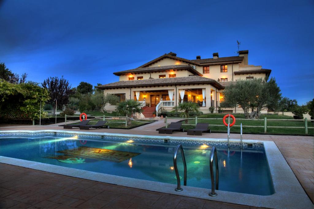 a house with a swimming pool in front of a house at Hostería de Guara in Bierge