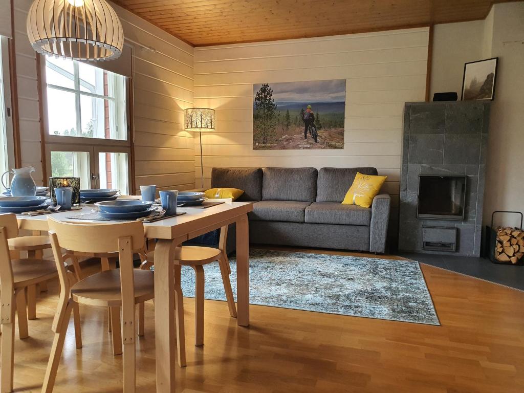 a living room with a table and a couch at Rakovalkia Apartment in Saariselka