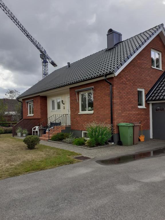 a red brick house with a crane in the background at Villa mitt i Ullared - 400m till Gekås in Ullared