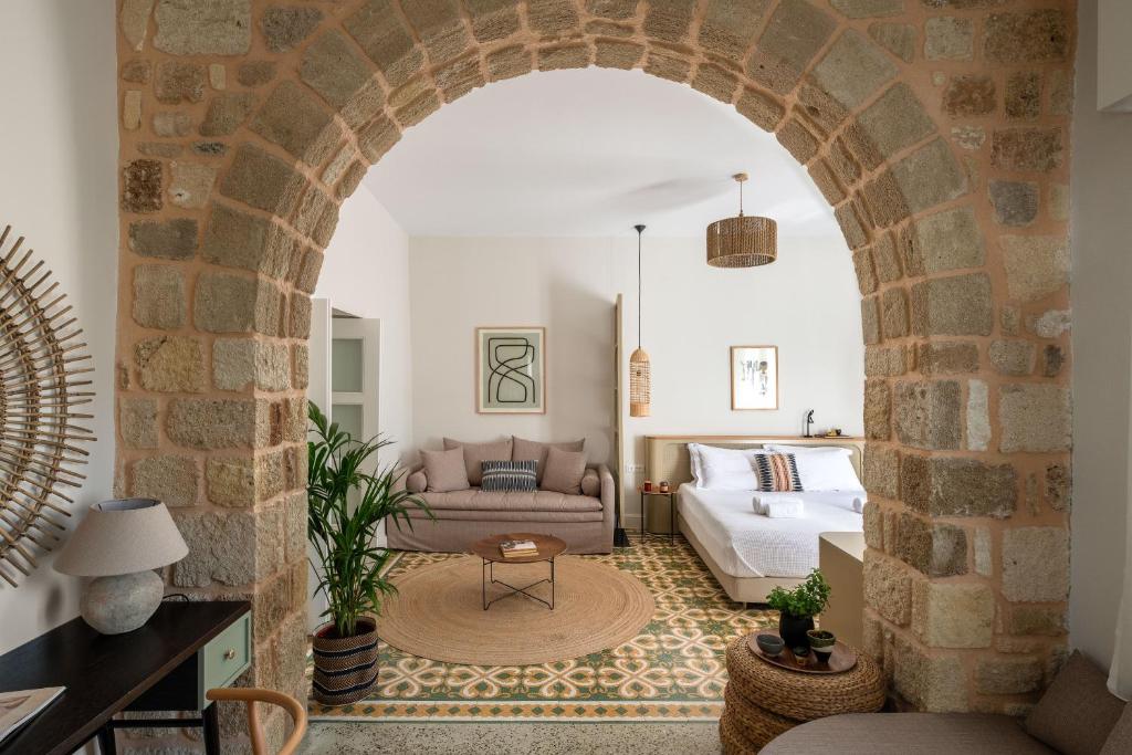 Habitación con un arco con cama y sofá en Casa Natura en Rodas